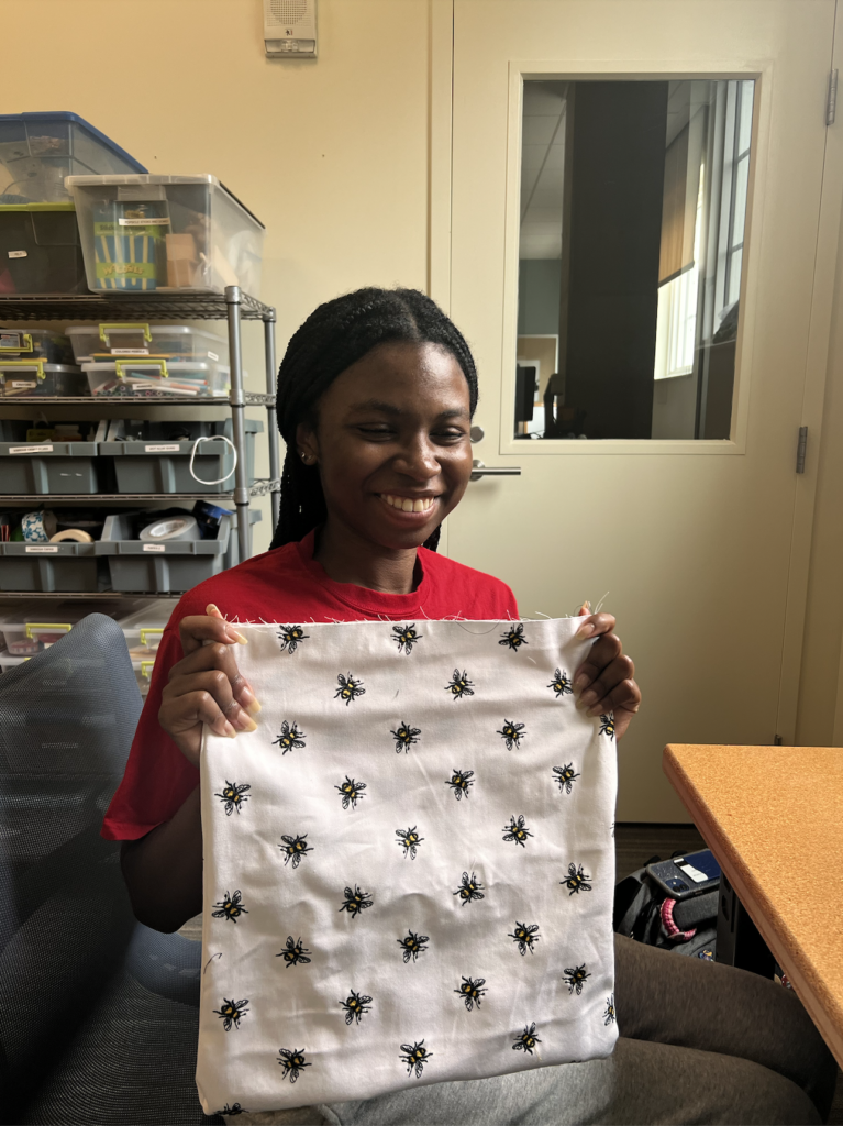 Young woman holding up the fabric for her project.