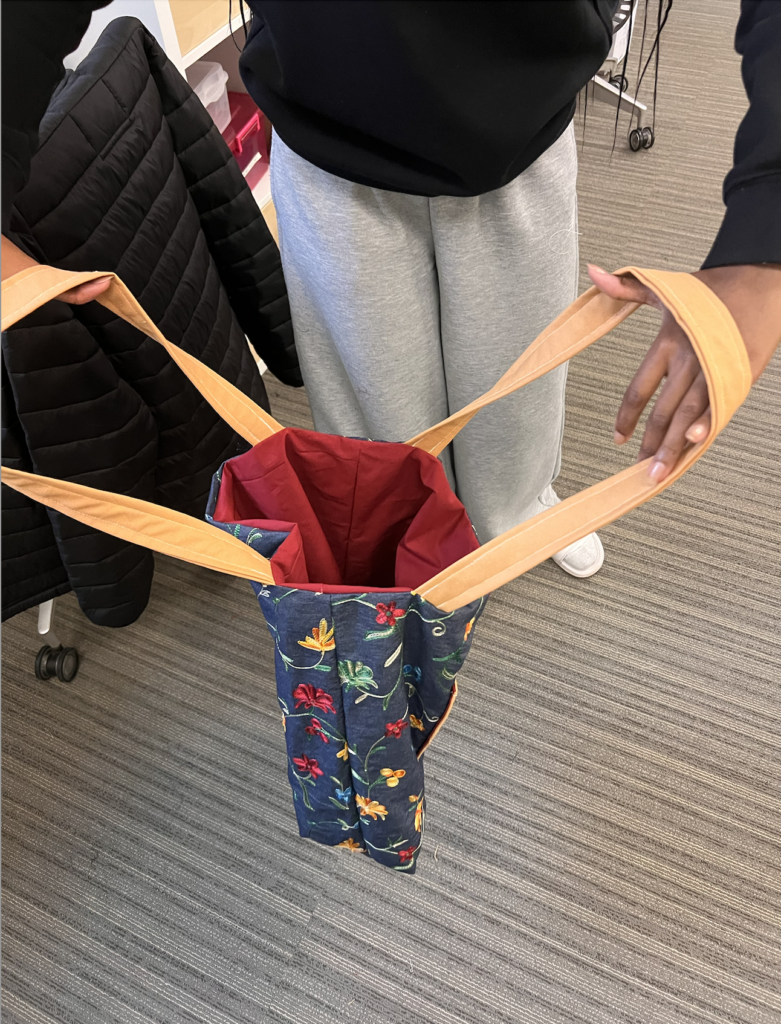 Person hold a tote bag open and looking done into the opening