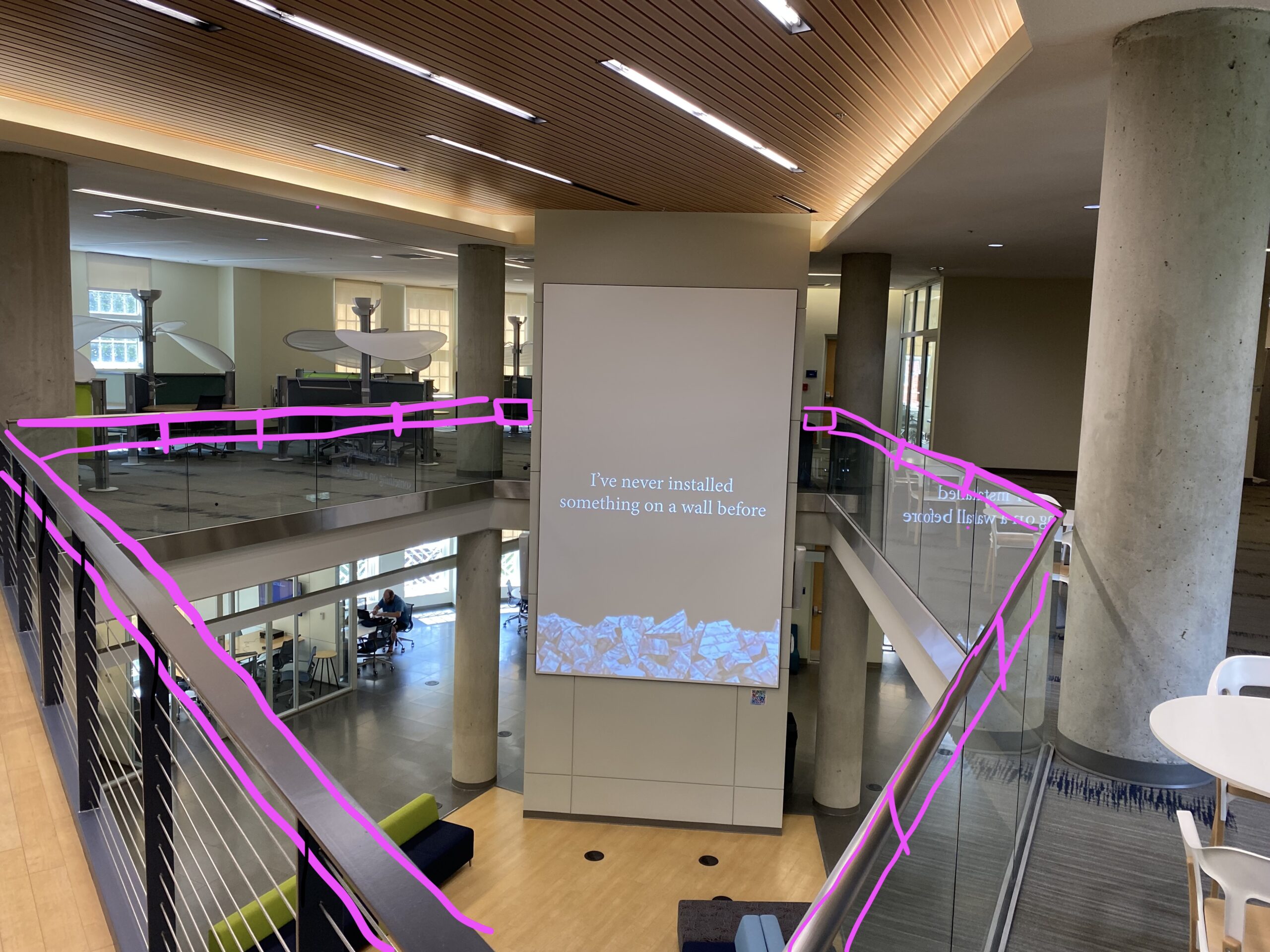 light strands wrapped around railing that surrounds an open atrium