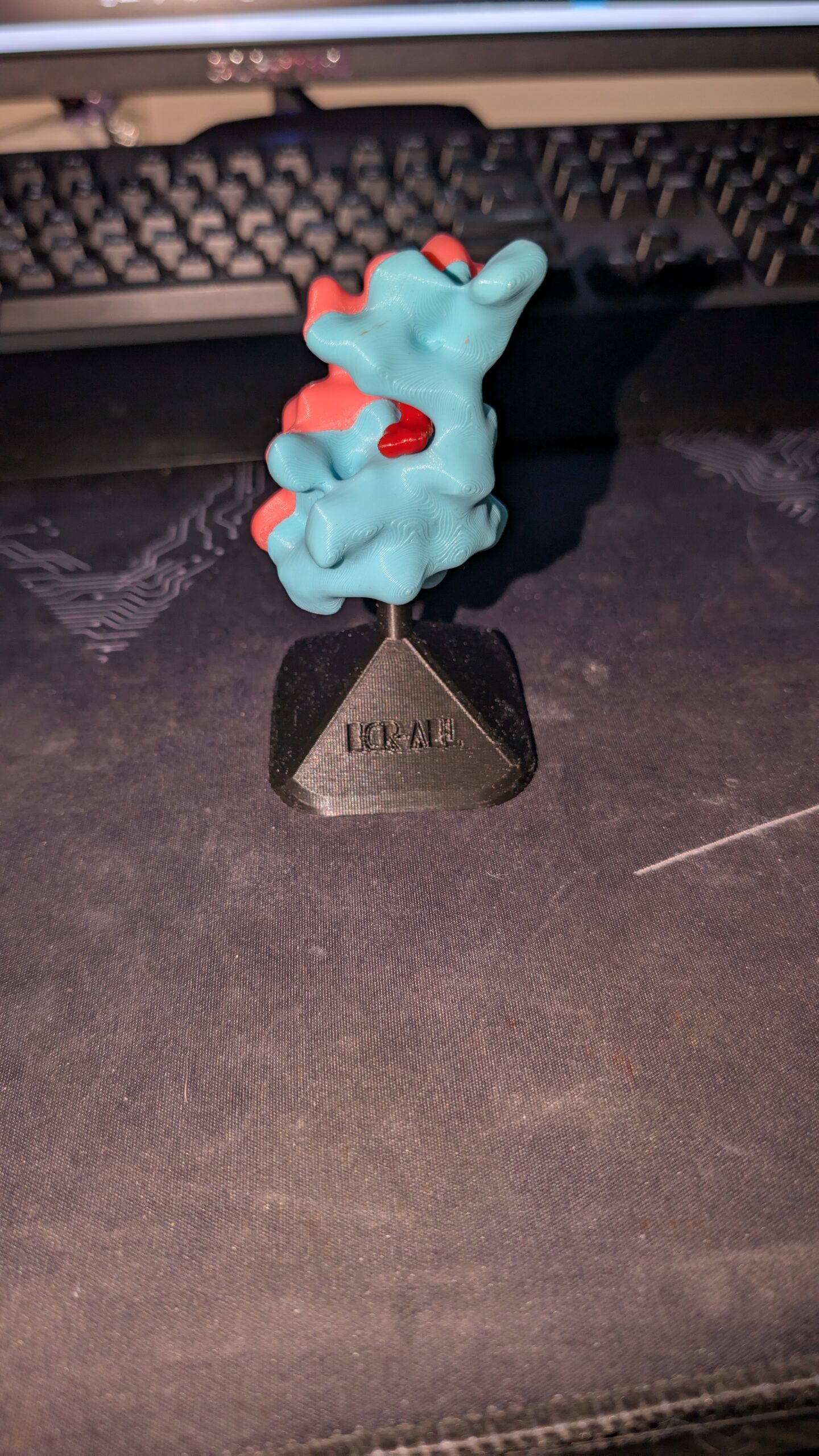 3D printed molecule with 3 distinct parts all together on a stand