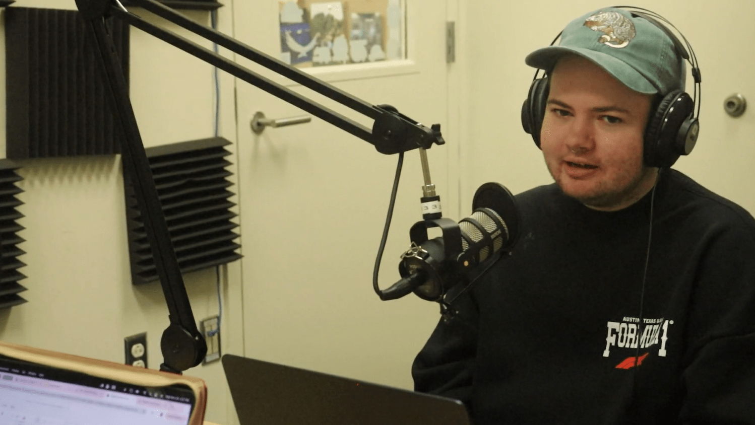 Andrew talking in front of a mic in podcast studio